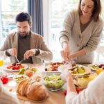 Four friends sharing a delightful meal indoors, highlighting friendship and togetherness.